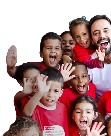 Eine Gruppe lächelnder Kinder, die winken und rote Colgate-T-Shirts tragen, neben einem lächelnden Mann in einem weißen Hemd