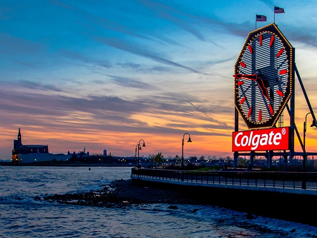 Meeresufer, Colgate-Logo im Hintergrund unter einer großen Uhr mit roten Zeigern